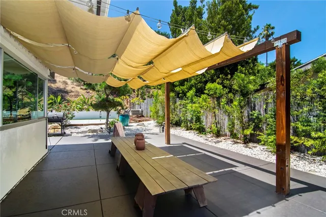 a view of a patio with table and chairs and potted plants
