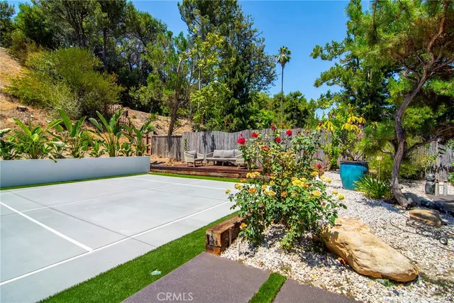 a view of yard with large tree and wooden fence