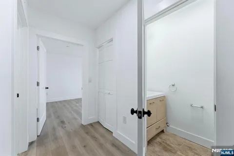 a view of a hallway with wooden floor and closet