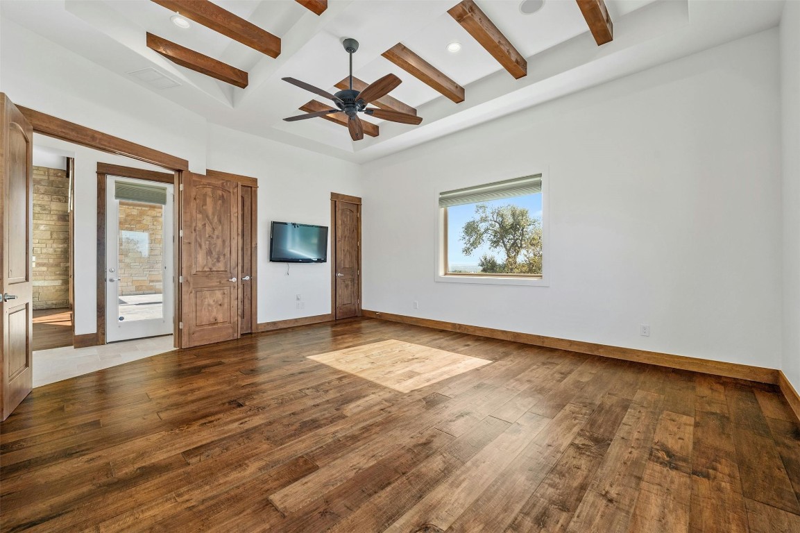 8040 Carlton Ridge Cove Austin, TX 78738 - Photo 20 of 40 an empty room with wooden floor chandelier fan and windows