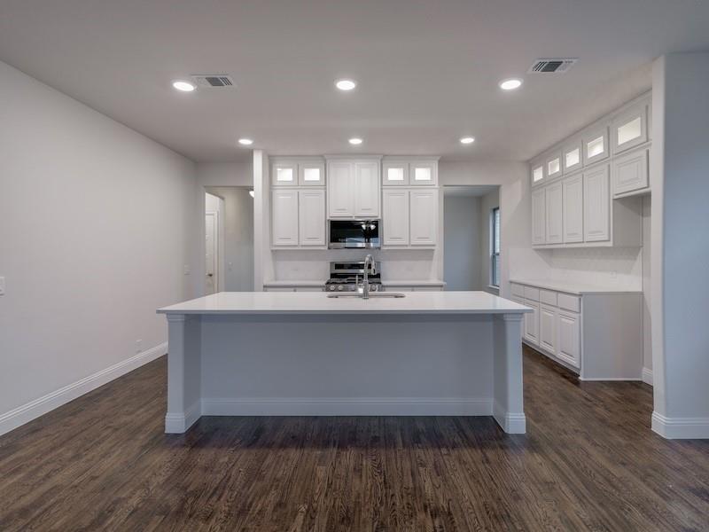 145 Winterwood Drive Lavon, TX 75166 - Photo 12 of 24 Kitchen with white cabinetry, sink, a kitchen island with sink, and dark wood-type flooring