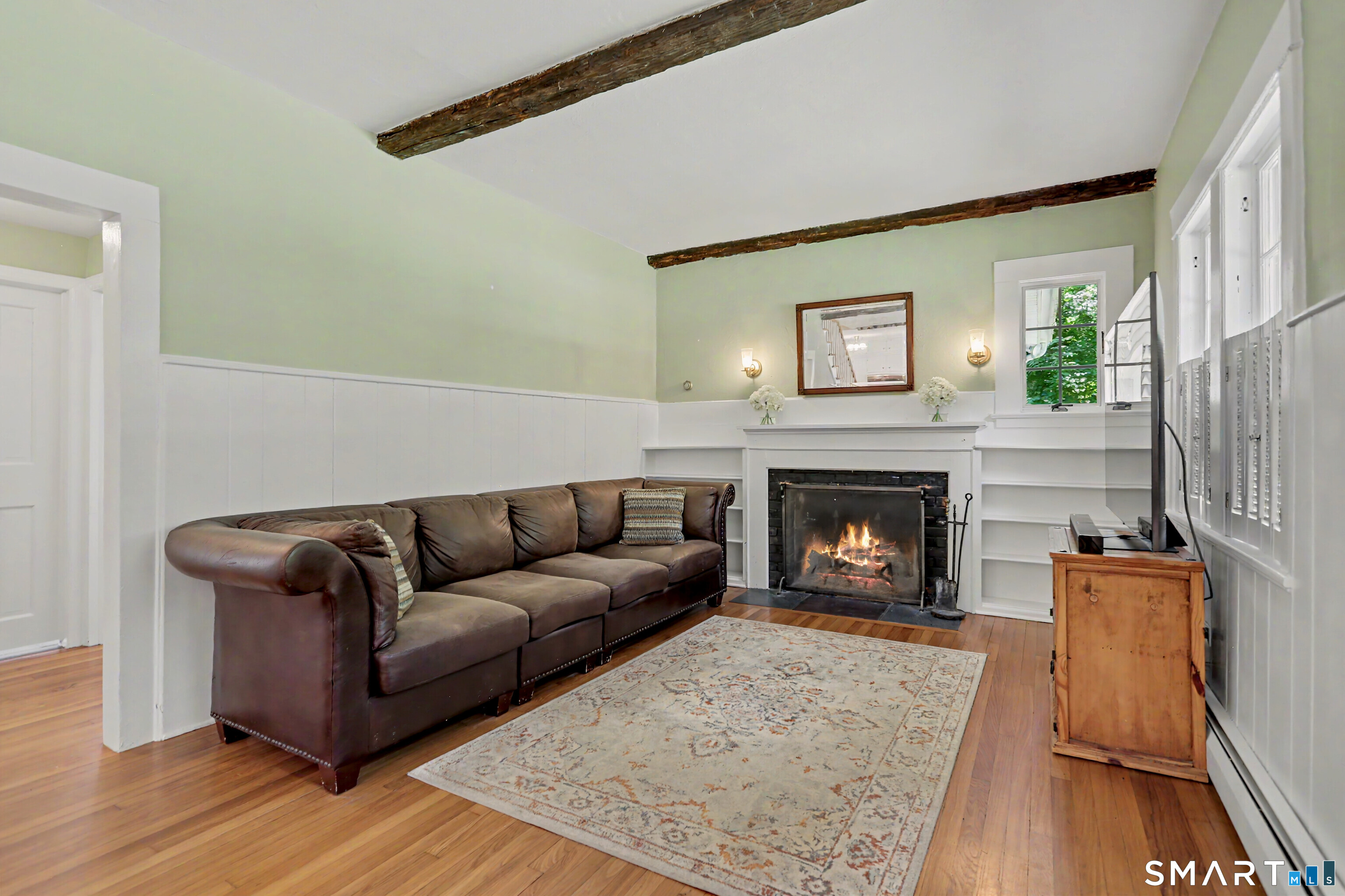 31 Vista Road Wilton, CT 06897 - Photo 6 of 34 Inviting family room with exposed beams, hardwood floors, built-ins, and a fireplace.