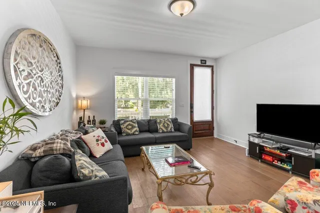 a room with stainless steel appliances kitchen island granite countertop furniture and a view of living room