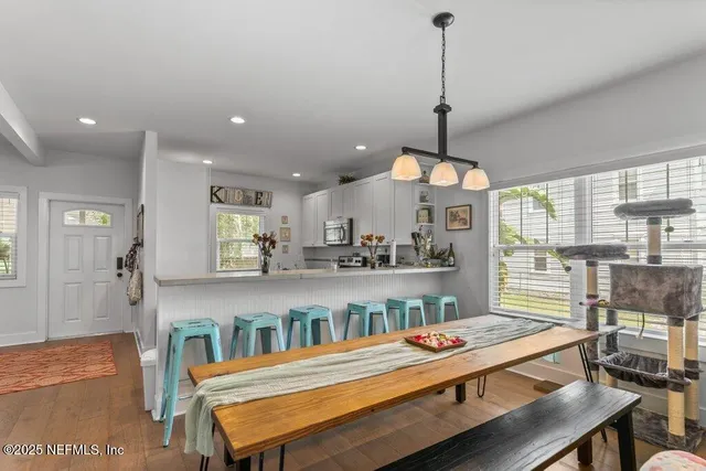 a living room with stainless steel appliances kitchen island granite countertop a sink and cabinets