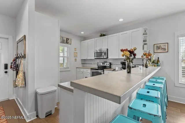 a kitchen with granite countertop white cabinets and white appliances