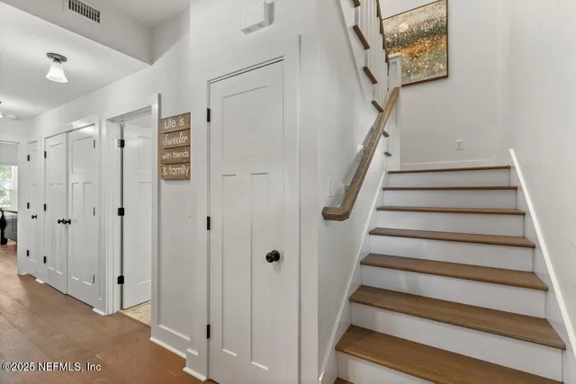 a view of a hallway with wooden floor and a bedroom