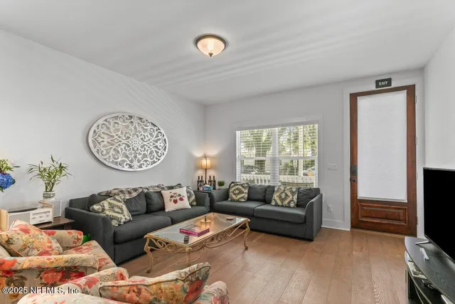 a living room with furniture kitchen view and a chandelier