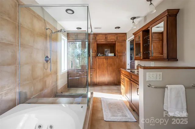 a bathroom with a tub a mirror and a shower