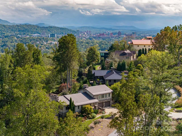 an aerial view of a house with yard and mountain view in back