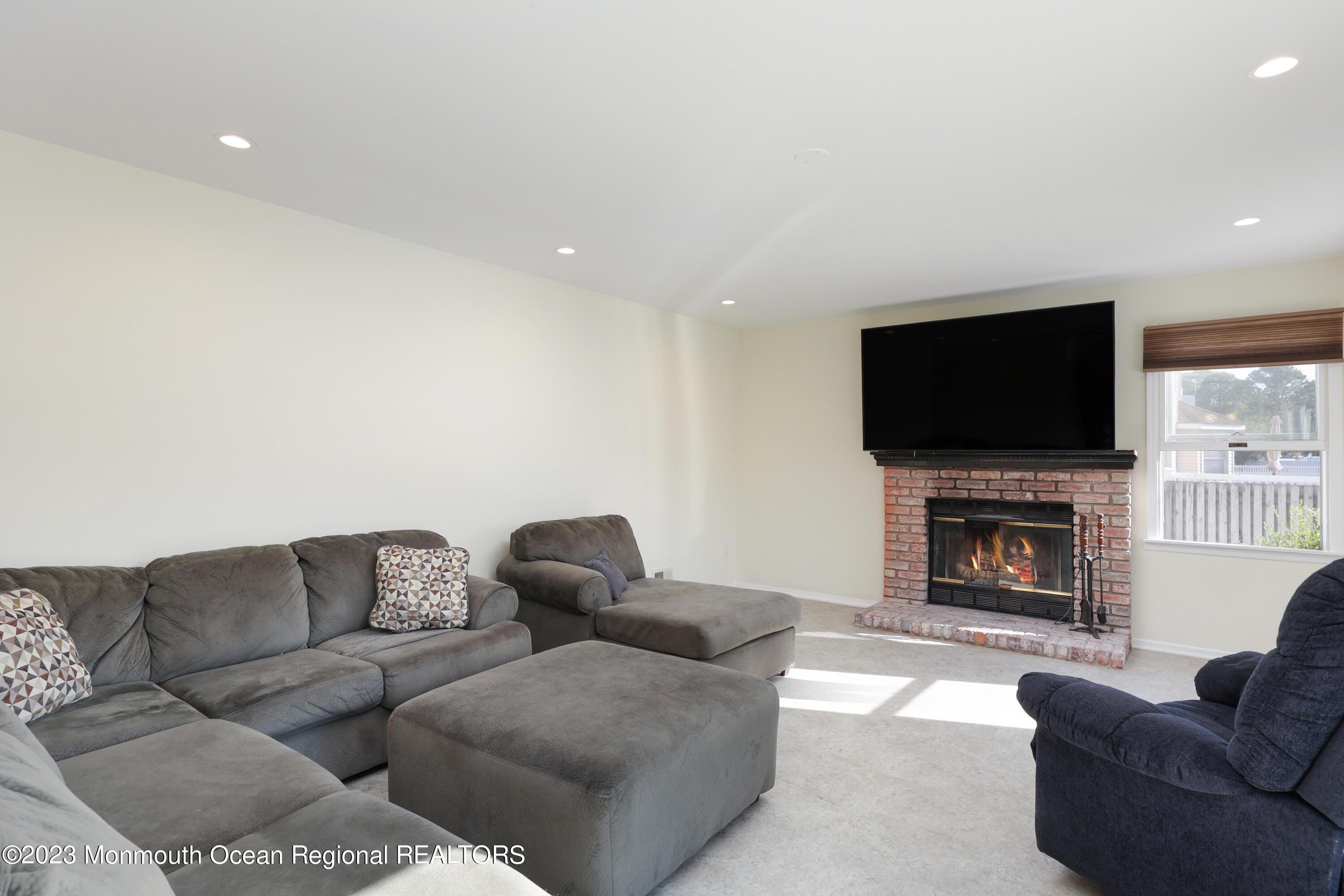 146 Jordan Road Brick, NJ 08724 - Photo 11 of 36 a living room with furniture a fireplace and a flat screen tv