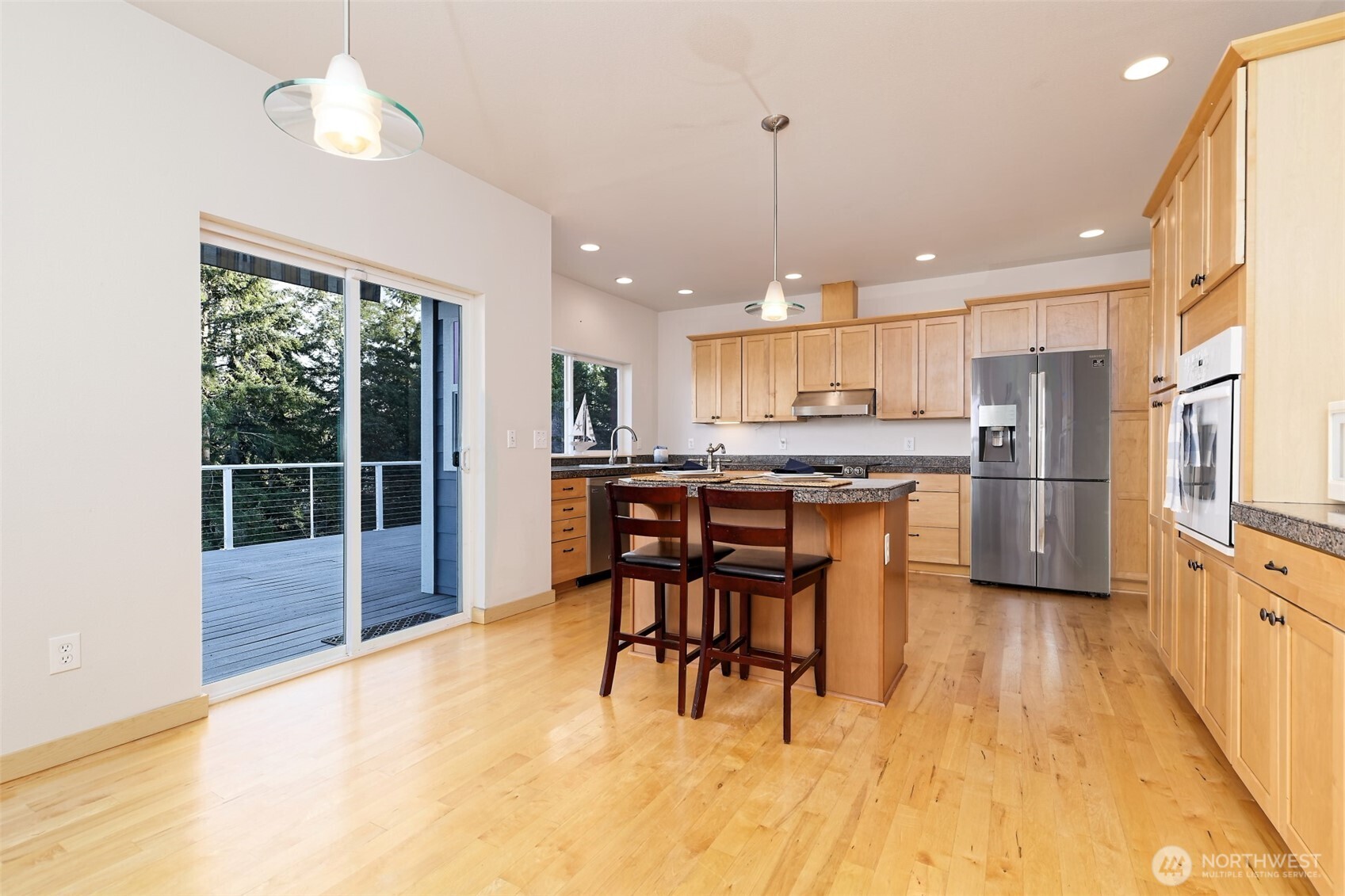 20 East Case View Place Shelton, WA 98584 - Photo 9 of 40 a kitchen with stainless steel appliances kitchen island granite countertop a refrigerator a stove a sink a dining table and chairs with wooden floor