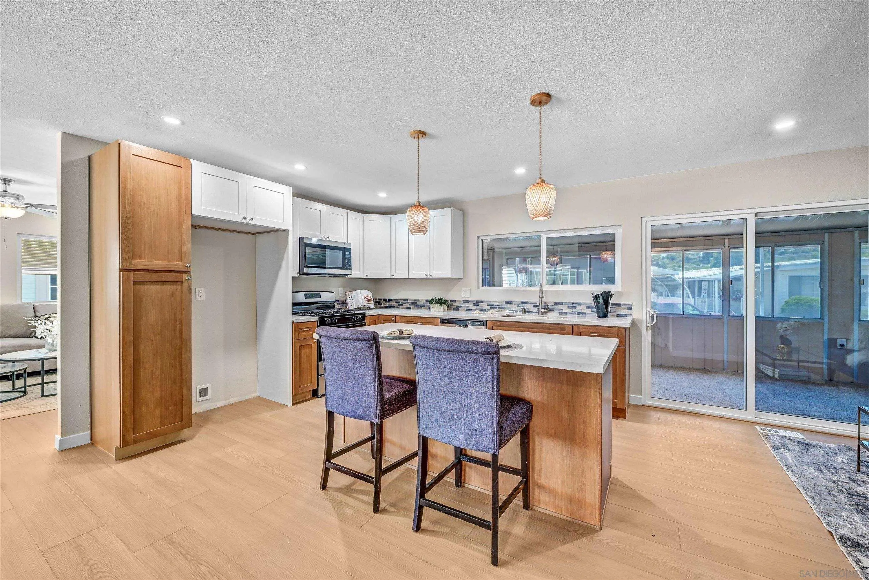a kitchen with stainless steel appliances kitchen island granite countertop a refrigerator a stove a sink dishwasher with a dining table and chairs