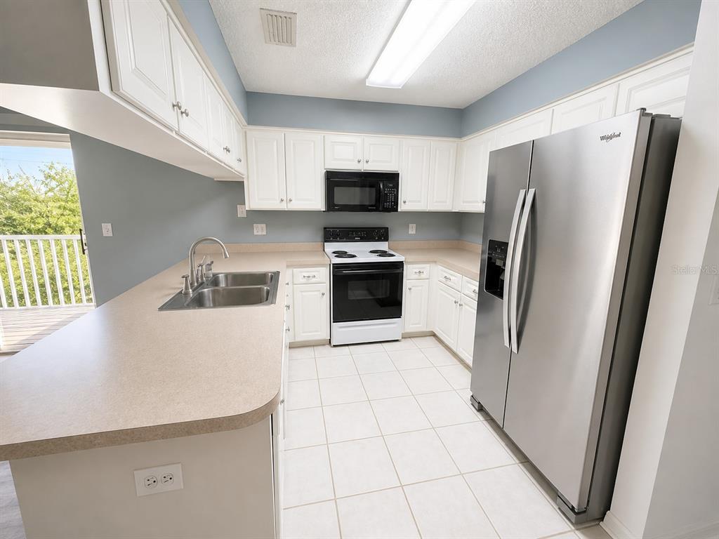 1013 Apollo Beach Boulevard, Unit 202 Apollo Beach, FL 33572 - Photo 6 of 18 a kitchen with stainless steel appliances a refrigerator sink and microwave