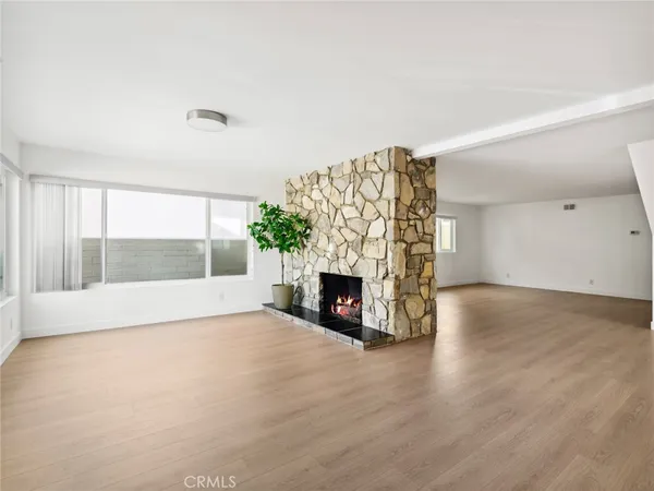 a view of an empty room with a fireplace and a window
