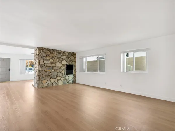 a view of empty room with wooden floor and fireplace