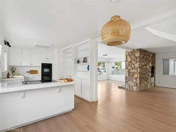 a hall with kitchen island granite countertop a wooden floor a rug and a fireplace