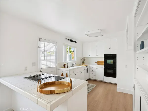 a large white kitchen with a stove a sink and a refrigerator