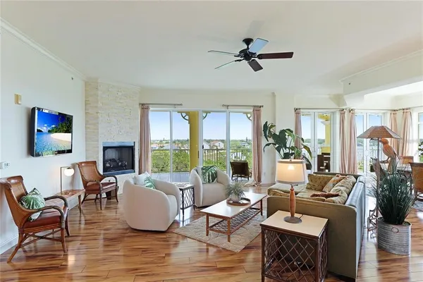 a living room with furniture large window and wooden floor
