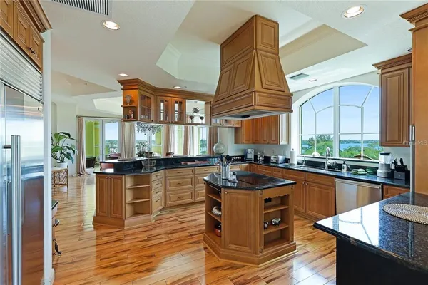 a kitchen with stainless steel appliances granite countertop a stove a sink and a refrigerator