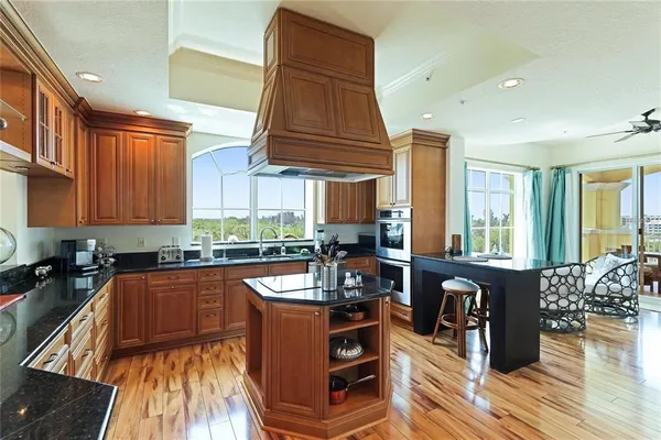 a kitchen with stainless steel appliances granite countertop a stove a sink dishwasher and cabinets with wooden floor