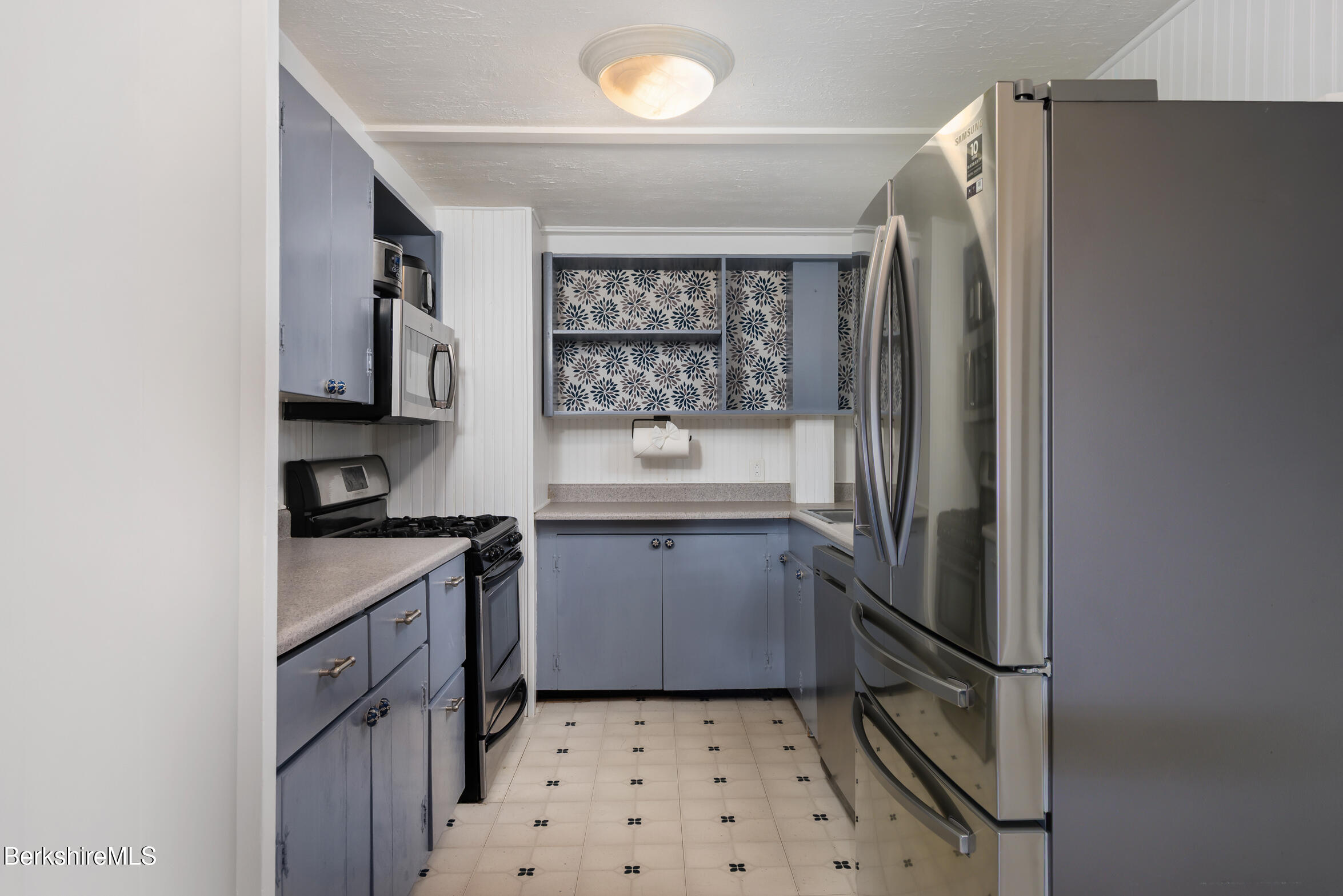 310 Luce Road Williamstown, MA 01267 - Photo 12 of 30 a kitchen with a refrigerator a sink and wooden cabinets