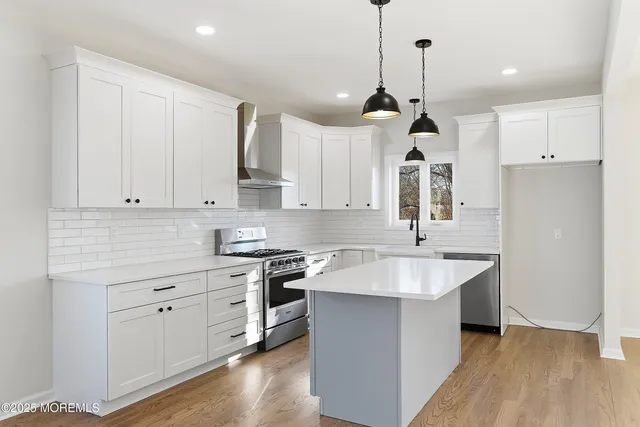 a kitchen with a stove and a wooden floor