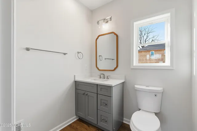 a view of an empty room with wooden floor and a ceiling fan
