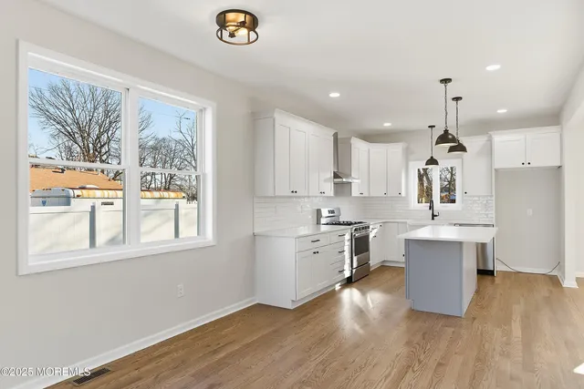 a kitchen with kitchen island a sink stainless steel appliances and cabinets