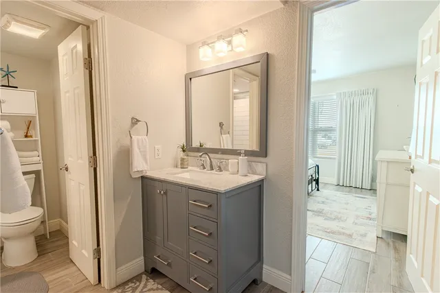 a bathroom with a sink a toilet and a mirror