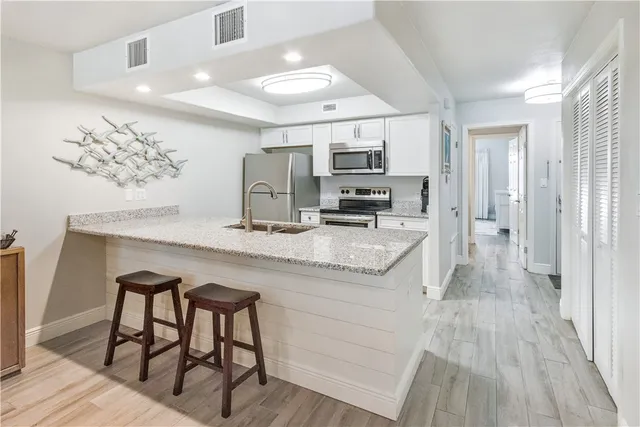 a kitchen with kitchen island a counter top space appliances and cabinets