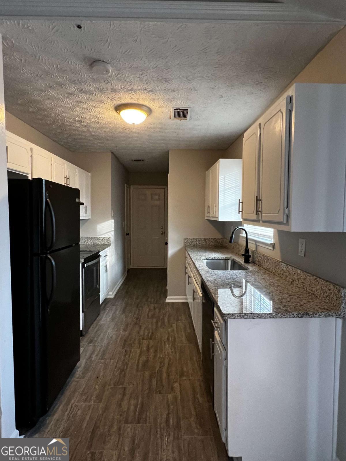164 Adrian Drive Stockbridge, GA 30281 - Photo 4 of 12 a kitchen with stainless steel appliances granite countertop a sink stove and refrigerator