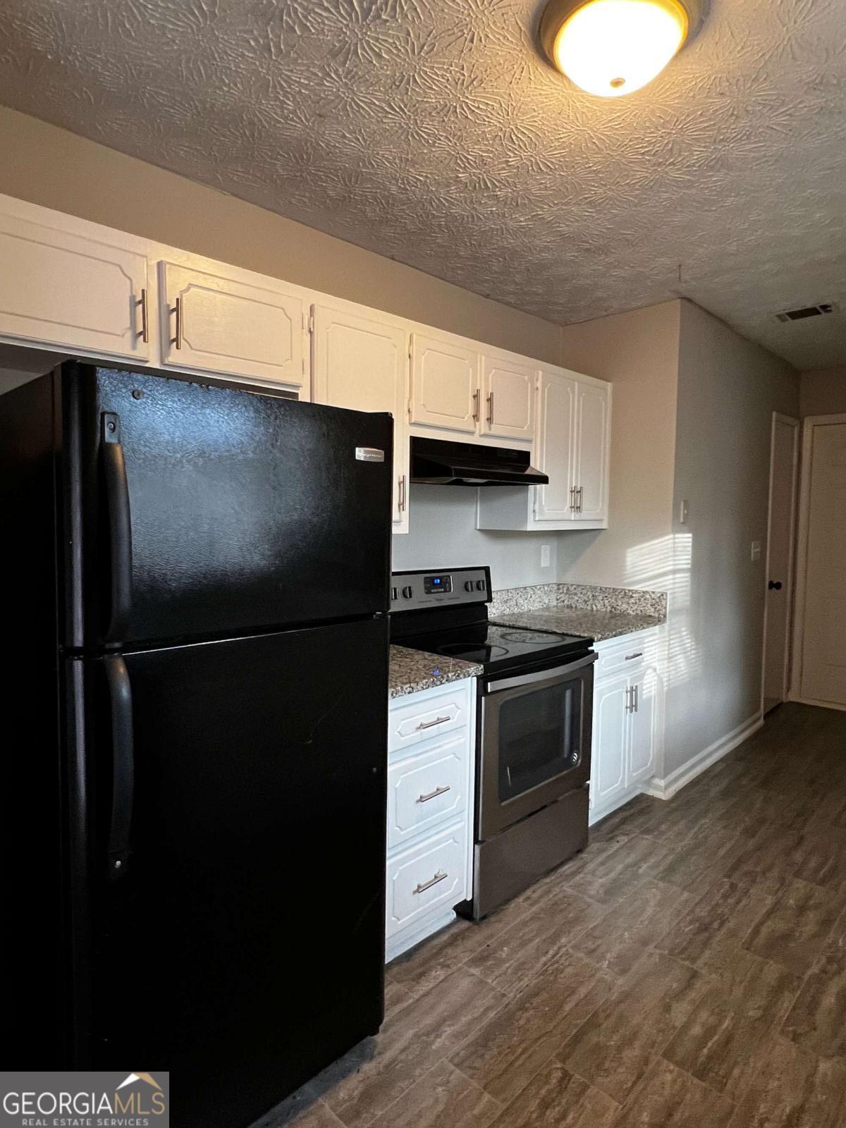 164 Adrian Drive Stockbridge, GA 30281 - Photo 6 of 12 a kitchen with stainless steel appliances a refrigerator and a stove