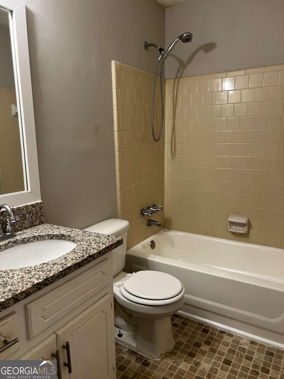 164 Adrian Drive Stockbridge, GA 30281 - Photo 10 of 12 a bathroom with a granite countertop toilet a sink and a bathtub