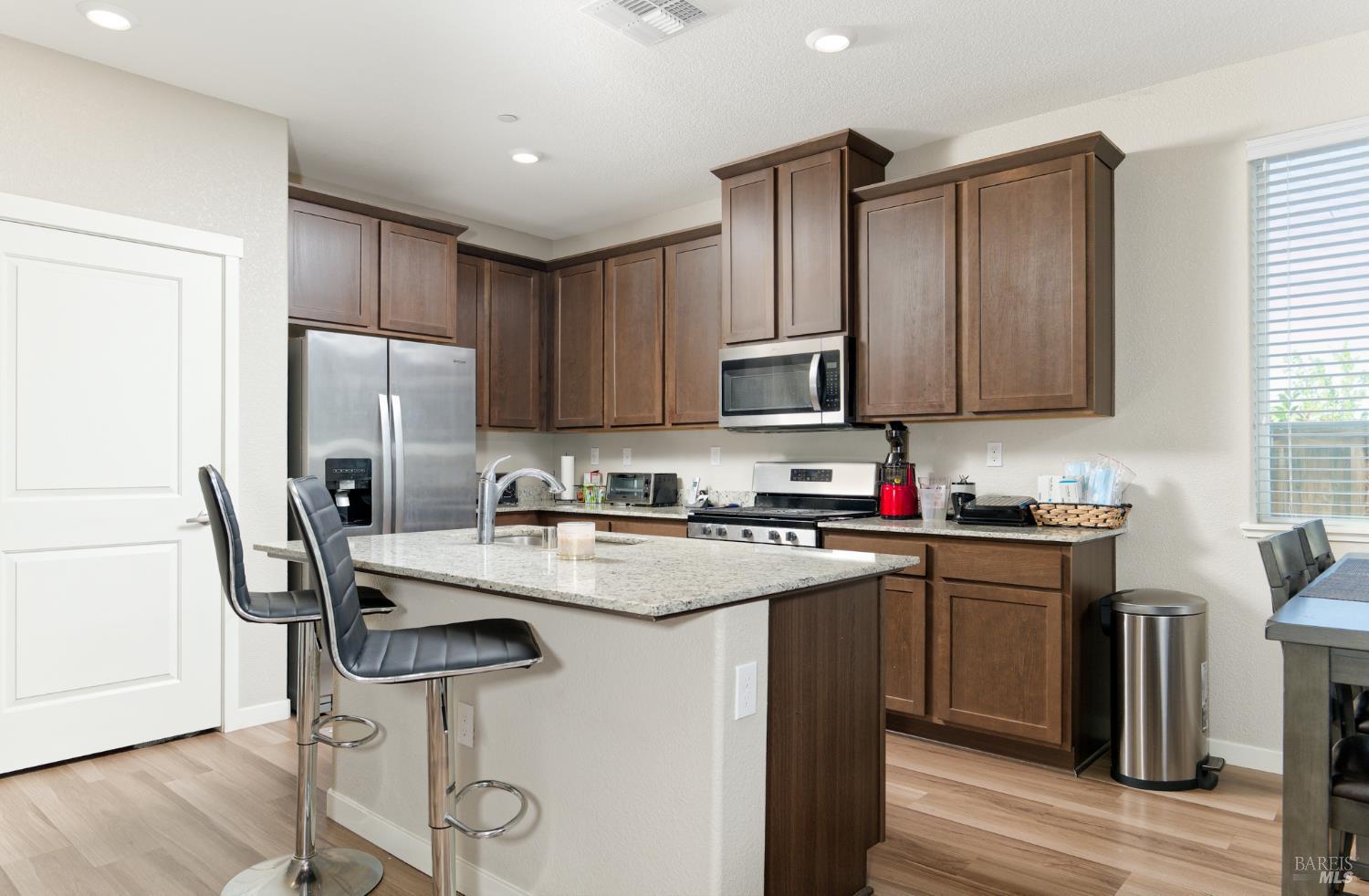 2211 Stars Drive Rio Vista, CA 94571 - Photo 12 of 24 a kitchen with stainless steel appliances granite countertop a refrigerator a stove a sink dishwasher and white cabinets with wooden floor