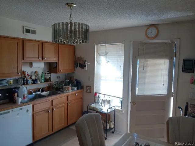 a kitchen with stainless steel appliances granite countertop a sink dishwasher a stove a refrigerator and cabinets with wooden floor