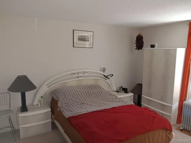 a bedroom with a bed a lamp and a window