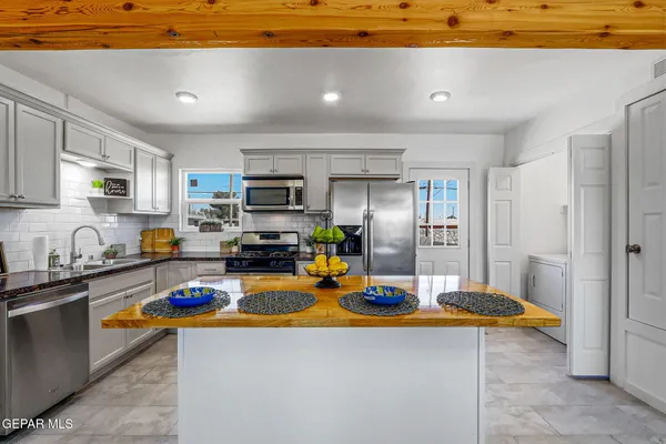 a kitchen with stainless steel appliances granite countertop a refrigerator stove top oven a sink and dishwasher
