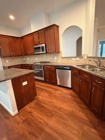 a kitchen with stainless steel appliances granite countertop a stove a sink dishwasher and a refrigerator