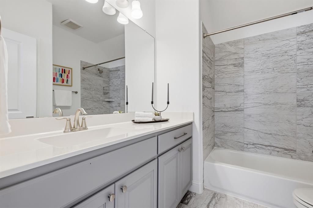539 Farrell Lane Allen, TX 75013 - Photo 29 of 39 Bathroom vanity with a white countertop and gray cabinetry, featuring an undermount sink and brushed nickel faucet