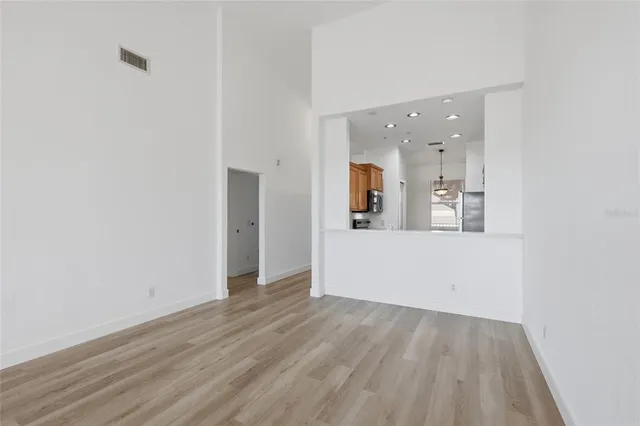 a view of a room with wooden floor and a ceiling fan
