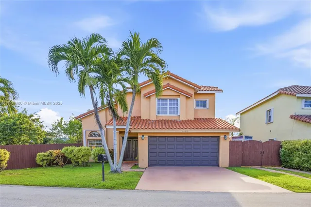 a front view of a house with a yard and garage
