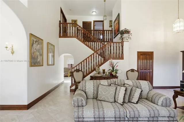 a view of a livingroom with furniture stairs wooden floor and windows
