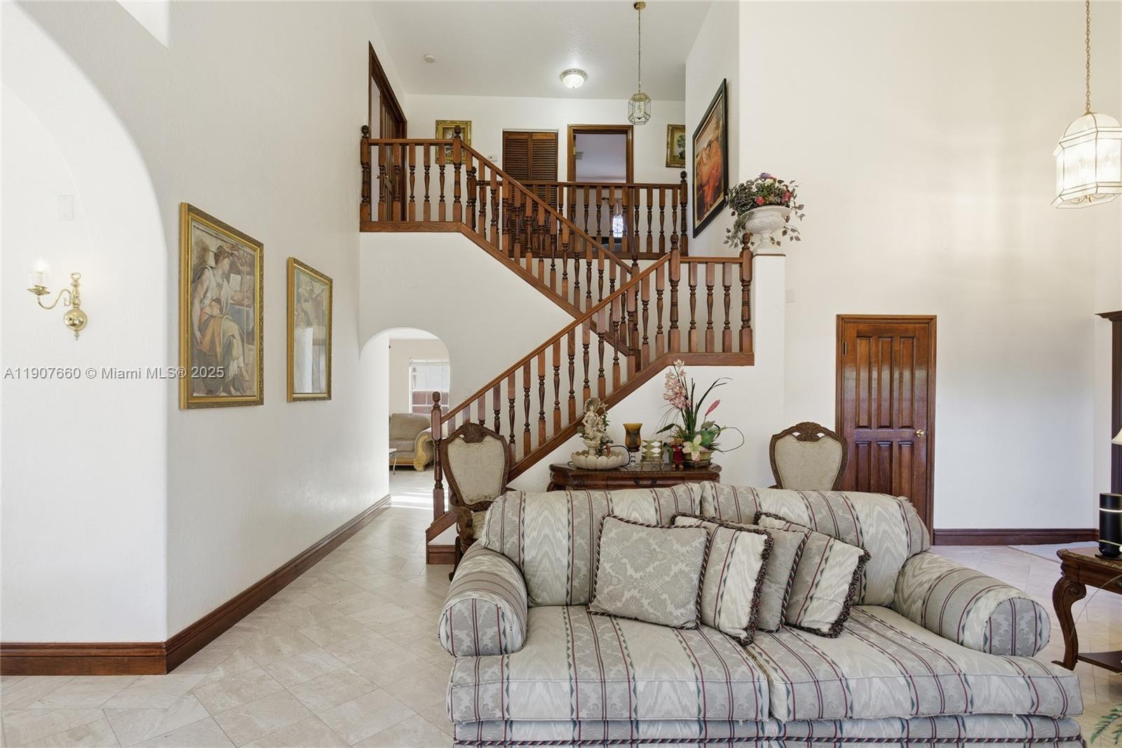 20816 Southwest 85th Place Cutler Bay, FL 33189 - Photo 13 of 49 a view of a livingroom with furniture stairs wooden floor and windows