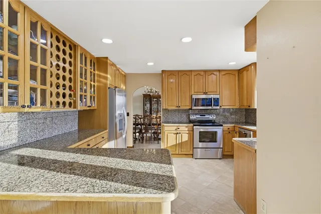 a kitchen with stainless steel appliances granite countertop a stove a sink and a microwave