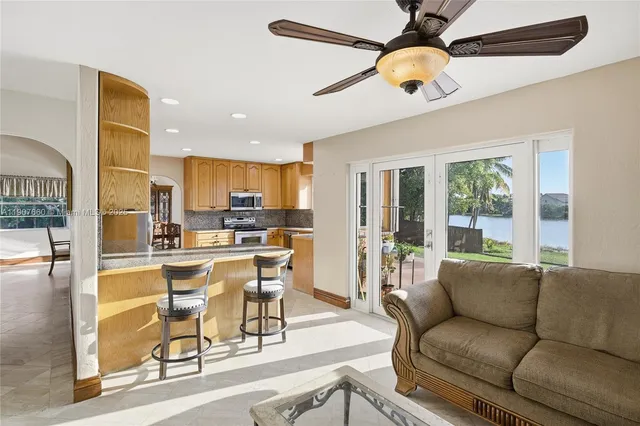 a living room with stainless steel appliances granite countertop furniture and a large window