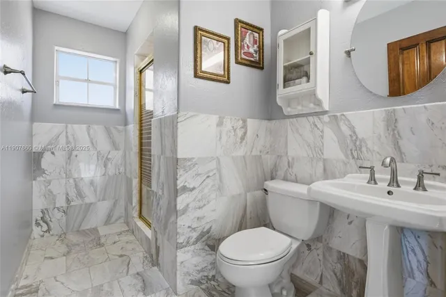 a bathroom with a sink toilet and mirror