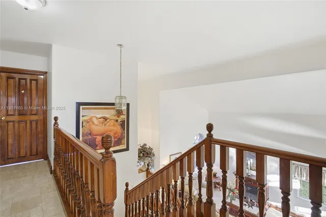 a view of a hallway with wooden floor and stairs