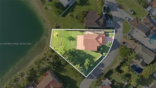 an aerial view of a residential houses with outdoor space and a lake view