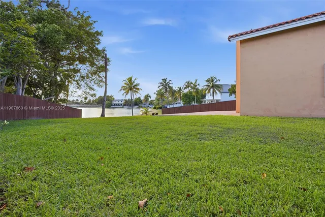 a view of yard with grass and a palm tree