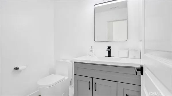 a bathroom with a sink vanity mirror and toilet